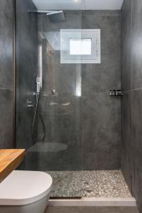 a bathroom with a glass shower with a toilet at Nikas Guest House in Kanálion