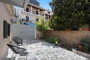 a patio with two chairs in front of a building at Nikas Guest House in Kanálion