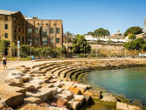 a water fountain in a city with buildings in the background at Modern Comfort in the Heart of Sydney in Sydney