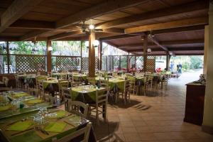 a dining room with tables and chairs in a building at Camping Village IL SOLE - Empty Pitch Only - Solo Piazzole per la propria tenda o caravan in Marina di Grosseto