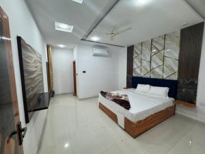 una camera da letto con un letto e una TV a schermo piatto di Raj Palace a Ajmer