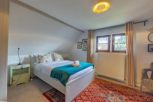 ein Schlafzimmer mit einem Bett, auf dem ein Teddybär liegt in der Unterkunft Liberté - Magnifique maison proche Strasbourg in Schiltigheim
