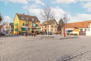 eine Straße in einer Stadt mit gelben und grünen Gebäuden in der Unterkunft Liberté - Magnifique maison proche Strasbourg in Schiltigheim + 10 Fotos