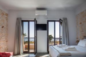 a bedroom with a bed with a view of the ocean at Chryssi 01, Stylish Seaside Spot in the Heart of Rethymno in Rethymno Town