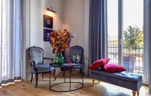 una sala de estar con mesa, sillas y un jarrón de flores en Gorgeous Apartment In Catania With Wifi, en Catania