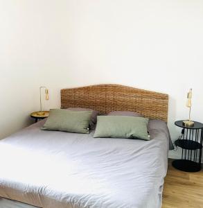 Un dormitorio con una cama grande con dos almohadas. en BO'M Appart, en Tourcoing