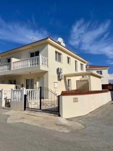 a white house with a black fence in front of it at Nissi Villa in Ayia Napa