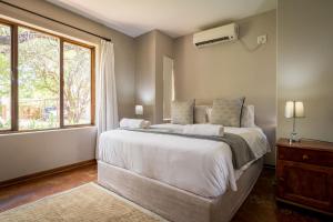 a bedroom with a large bed and a window at Raptors Wildlife Escapes in Hoedspruit