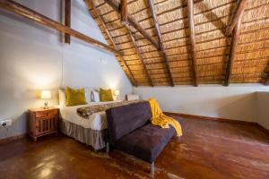 a bedroom with a bed and a chair in a room at Raptors Wildlife Escapes in Hoedspruit