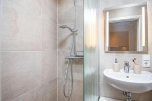 ein Badezimmer mit Waschbecken und Dusche in der Unterkunft Huus Gerda in Krummhörn