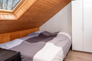 ein Schlafzimmer mit einem Bett und einer Holzdecke in der Unterkunft Huus Gerda in Krummhörn