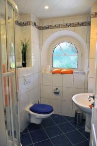 a bathroom with a toilet and a sink at Exklusives Ferienhaus "Waldzauber" Ruhe und Natur pur am Waldrand genießen in Schönheide
