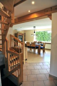 a dining room and living room with a table and chairs at Exklusives Ferienhaus "Waldzauber" Ruhe und Natur pur am Waldrand genießen in Schönheide