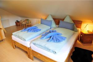two beds with blue towels on them in a room at Exklusives Ferienhaus "Waldzauber" Ruhe und Natur pur am Waldrand genießen in Schönheide