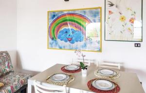 a table with plates and a rainbow on the wall at 2 Bedroom Stunning Apartment In Isola Capo Rizzuto in Isola Capo Rizzuto