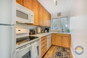 eine Küche mit weißen Geräten und Holzschränken in der Unterkunft Modern Lake Geneva Condo with Year-Round Views in Lake Geneva