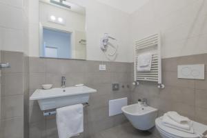 łazienka z umywalką, toaletą i lustrem w obiekcie Casole Living B&B w mieście Copertino +31 zdjęć
