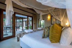a bedroom with a large white bed with pillows at Raptors Lodge in Hoedspruit
