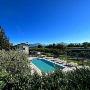 a swimming pool with lounge chairs and a house at Agriturismo & Agricamping Serena in Pastrengo