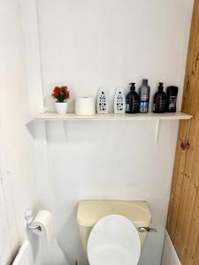 a bathroom with a toilet with a shelf on the wall at Premium Cozzy Corner in Leicester