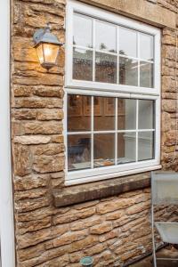 un muro di pietra con finestra e lampada di Secret View Cottage, A Hidden Gem in Terrington a Terrington