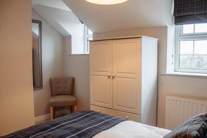 una camera da letto con un letto, un armadio e una sedia di Secret View Cottage, A Hidden Gem in Terrington a Terrington Altre 40 foto