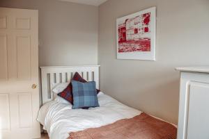 un letto bianco con un cuscino blu sopra di Secret View Cottage, A Hidden Gem in Terrington a Terrington