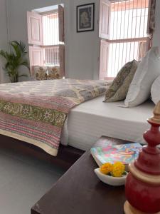 a bedroom with a bed and a table with a plate of flowers at NILAY House Varanasi Near Assi Ghat in Varanasi
