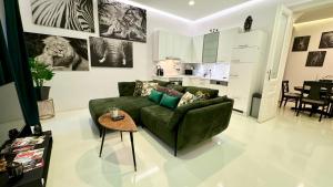 a living room with a green couch and a table at African Paradise with Jacuzzi & Sauna in Vienna