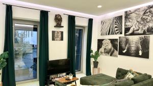 a living room with a green couch and pictures on the wall at African Paradise with Jacuzzi & Sauna in Vienna