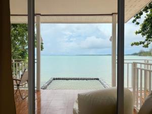 a room with a view of the ocean from a balcony at Baan Konhualam Koh Libong in Ko Libong Island
