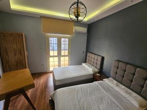 a bedroom with two beds and a chandelier at Azarita luxury apartment - families only in Alexandria