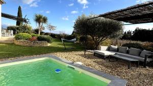 a swimming pool in a yard with a couch at Villa de vacances au coeur de la Provence près du Mont Ventoux avec piscine et climatisation in Sarrians