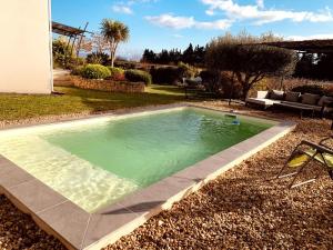 a swimming pool in the yard of a house at Villa de vacances au coeur de la Provence près du Mont Ventoux avec piscine et climatisation in Sarrians +6 photos