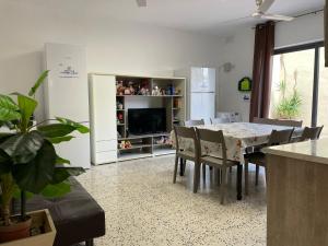 a dining room with a table and chairs and a television at Joan Apartment in Is-Swieqi