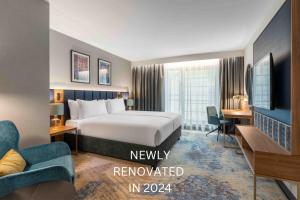 ヴロツワフにあるWyndham Wroclaw Old Townのベッド、ソファ、デスクが備わるホテルルームです。