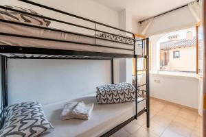 a bedroom with two bunk beds and a balcony at Beach House Roda de Bera in Roda de Bará