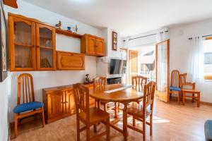 a kitchen and dining room with a wooden table and chairs at Beach House Roda de Bera in Roda de Bará
