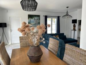 サン・ドニ・ドレロンにあるVilla Clara, 600m de la mer, piscineのリビングルーム(青いソファ、花のテーブル付)