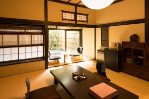 Ito Ryokuyu في إيتو: غرفة معيشة مع طاولة وبعض الكراسي