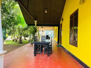 a table and chairs sitting on the porch of a house at Ceylon Safari Cottage in Udawalawe