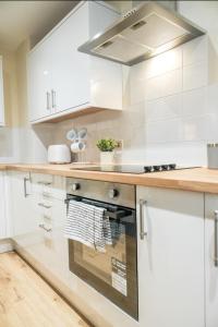 a kitchen with white cabinets and a stove at Katrina Suite in Boston +36 photos