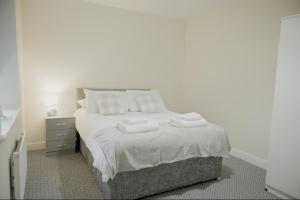 a bedroom with a bed with towels on it at Katrina Suite in Boston