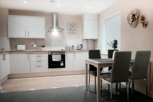 a kitchen with white cabinets and a table and chairs at Katrina Suite in Boston