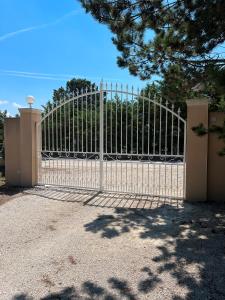 une grande porte blanche avec une clôture dans l'établissement Villa avec piscine, à Châteauneuf-de-Gadagne