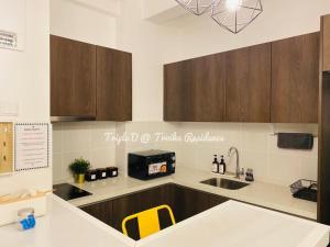 a kitchen with wooden cabinets and a counter top at Triple D @ Troika Residence in Kota Bharu