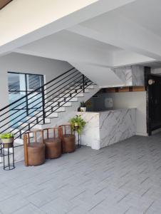 a lobby with a staircase and a counter with plants at Grand UNX in Kannur