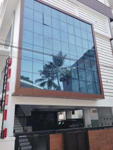 un reflejo de una palmera en las ventanas de un edificio en Grand UNX, en Kannur