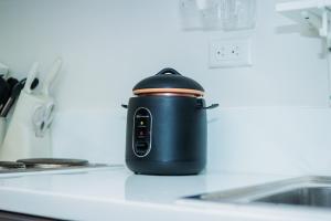 a black slow cooker sitting on a kitchen counter at Quirky Urban Luxury Nest 1 Blazing fast 300Mbps in Manila