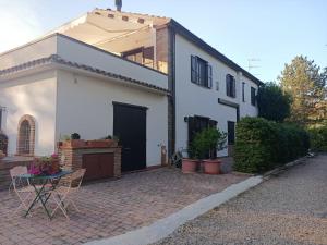 a white house with a patio and a table at Naturaliterre Agriturismo - Microfattoria in Dovadola